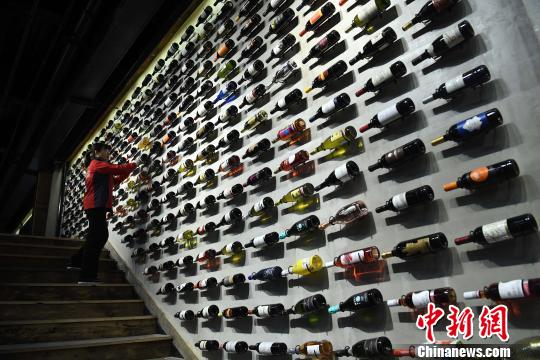 图为工作人员正在展厅内擦拭红酒瓶?！〕鲁?摄