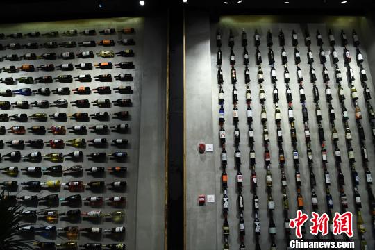 图为展厅内墙壁山挂满了各类红酒?！〕鲁?摄
