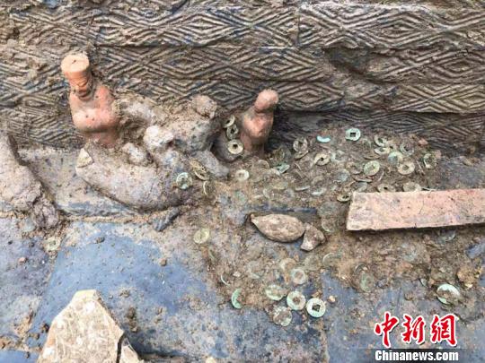 图为墓葬出土的陶俑和铜钱。(钟欣摄)