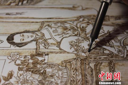 图为正在创作中的烙画作品?！⌒煅?摄