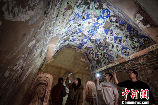 图为民众观赏1：1复原仿真洞窟?！〈蘖?摄