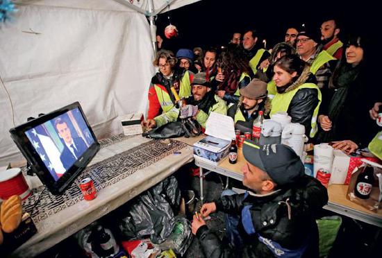 　12月10日，法国“黄背心”们观看法国总统马克龙的电视讲话。马克龙宣布法国进入“经济和社会的紧急状态”，并承诺从2019年起，将提高最低工资标准、不会轻易增税。图/视觉中国