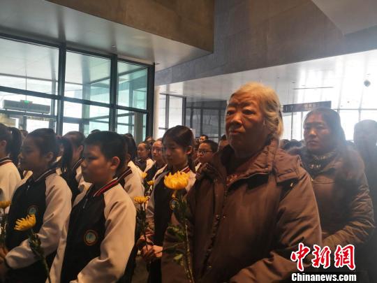 殉难者家属和观众代表向七三一部队殉难者名录献花?！∥豪?摄