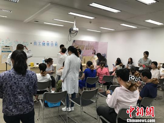 医务人员定期到各个楼宇、大厦送健康。量血压和医疗咨询等服务让白领受益匪浅。　芊烨 摄