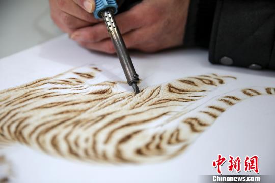 张茆生用火烧热烙铁在物体上熨出烙痕作画 王萍 摄 张茆生用火烧热烙铁在物体上熨出烙痕作画 王萍 摄
