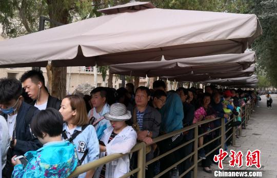 图为2018年8月中旬，莫高窟前等候参观的应急游客排成近1公里长队。(资料图) 冯志军 摄