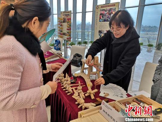 展览单位正在向观众展示竹蜻蜓。　童笑雨 摄