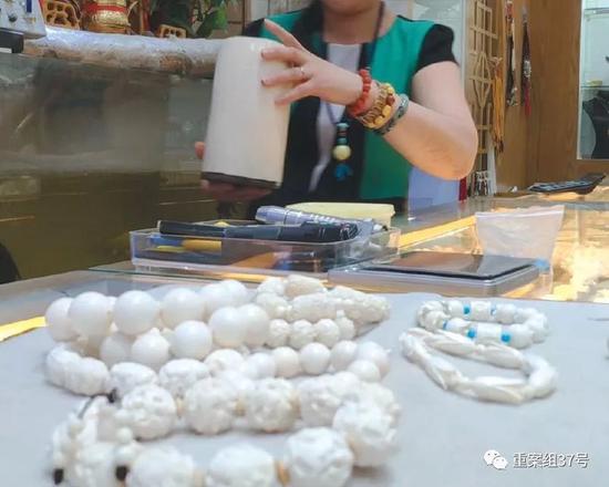 2018年8月11日，北京十里河雅园国际珠宝厅内，一猛犸象牙销售商向记者展示店内隐藏的现代象牙制品，其手中拿的是现代象牙所制的笔筒。  新京报记者王嘉宁 摄