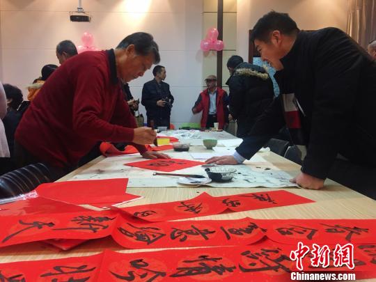 图为书法爱好者为师生写春联?！≌喷?摄