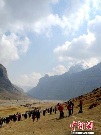 西藏阿里地区独特的自然风光及具有深厚文化底蕴和举世闻名的人文景观，吸引着越来越多的游客走进阿里，旅游业也让当地民众得到越来越多的实惠。图为国内外游客及信众在冈仁波齐神山脚下?！∧崧甓僦?摄