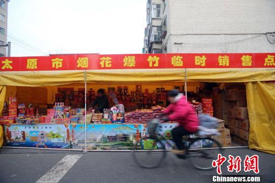 资料图:民众从烟花爆竹销售点经过。张云 摄 点击进入下一页