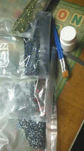 钻石画代加工者用于粘钻石画的胶水和颗粒，只能闲置在家中。 受访者供图