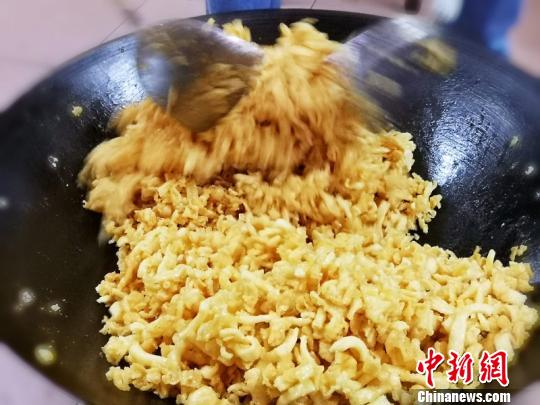 浇上糖浆的玛仔需迅速用锅铲拌匀 李晓春 摄 浇上糖浆的玛仔需迅速用锅铲拌匀 李晓春 摄