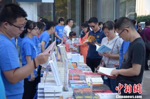 资料图:人们在文化惠民消费季现场展位前看书 余皓 摄 资料图:人们在文化惠民消费季现场展位前看书 余皓 摄