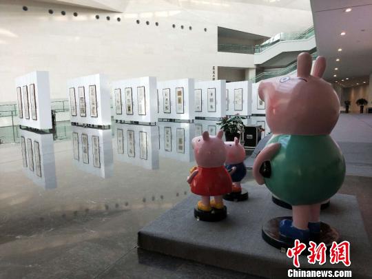 小猪佩奇“一家四口”站立在漫画展的对面，正远远观望着。　杨佩佩 摄