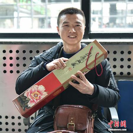 陈先生给家人带回一份装裱精致的牡丹挂历。<a target='_blank' href='http://www.chinanews.com/' >中新网</a>记者 翟璐 摄 点击进入下一页