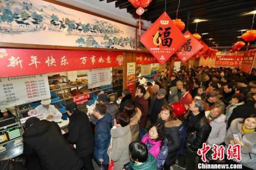 资料图：民众排长队购熟食备年货?；络?摄