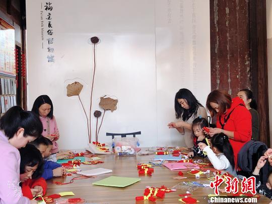 家长带着小朋友参与趣味手工体验活动?！∫肚镌?摄