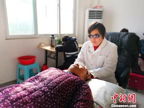 在社区服务中心，刘奉智母亲为村里人按摩，刘奉智在一旁写作业?！『卵Ь?摄