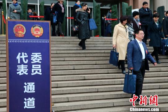 图为会议结束后，政协委员们从委员通道走出会场?！×籂?摄