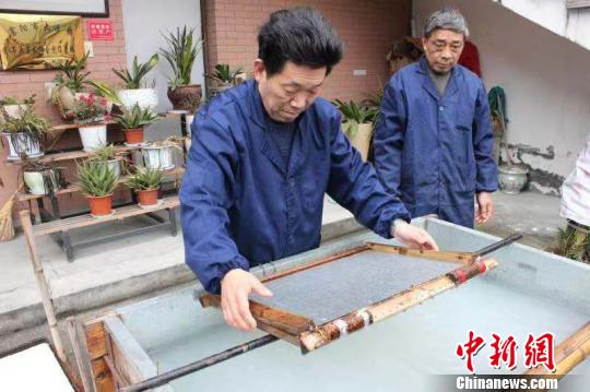 庄富泉正在制作竹纸?！∨硐?摄