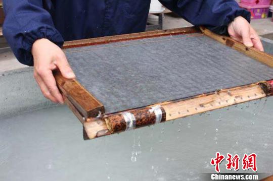 庄富泉正在制作竹纸?！∨硐?摄