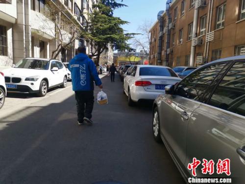 图为饿了么配送员正在送餐。 谢艺观 摄