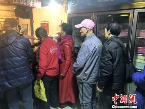 资料图：餐厅内排队打饭的民众?！「哳?摄