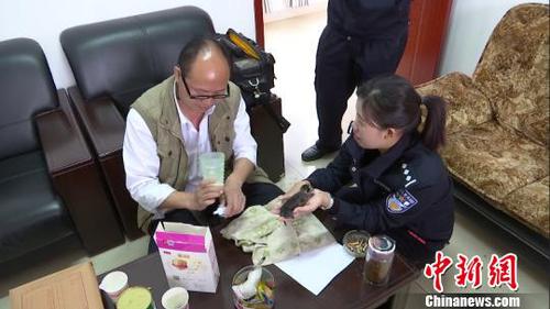 图为动物专家给豹猫宝宝冲泡奶粉。　金平县自然资源公安局供图 摄