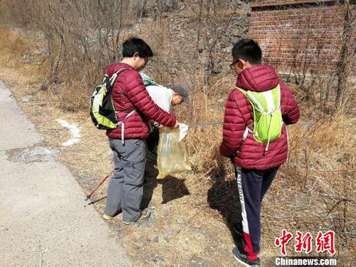 图为活动参与者在拣拾路边的垃圾。招嘉虹/摄 招嘉虹 摄