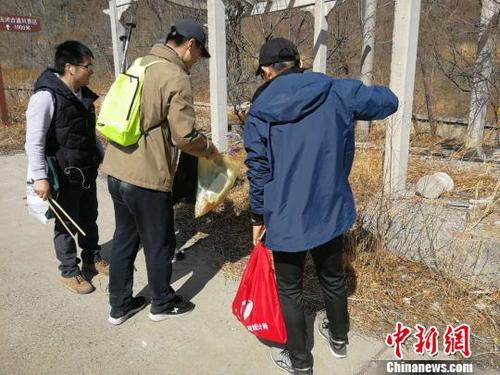 登山队员们一手握夹子、一手拎袋子，开展登山捡拾垃圾活动。招嘉虹/摄 招嘉虹 摄