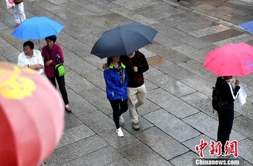 资料图:雨中的行人。<a target='_blank' href='http://www.chinanews.com/'>中新社</a>记者 吕明 摄 点击进入下一页