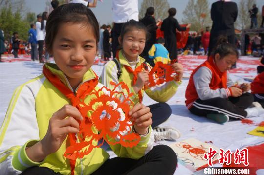 小学生们展示剪纸牡丹?！『略?摄