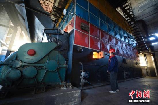 资料图。内蒙古呼和浩特一燃煤锅炉房内，工作人员操作供暖设备。<a target='_blank' href='http://www.chinanews.com/'>中新社</a>发 刘文华 摄