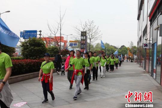 专业教练演示健走的标准姿势及正确的热身方式，并带领参赛人群进行实地健走活动。　陈静 摄