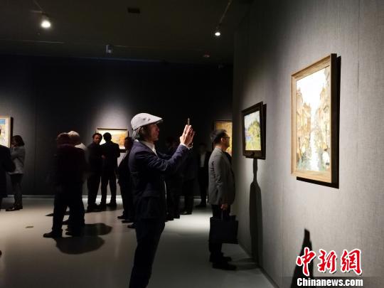 图为，在“印象山东——俄罗斯油画家写生作品展”上，观众在喜欢的作品前驻足观赏、拍照?！∷锖觇?摄