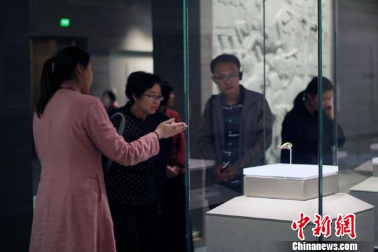 图为，观众在孔子博物馆展品前驻足观赏，仔细聆听讲解员解说?！⊥醴?摄