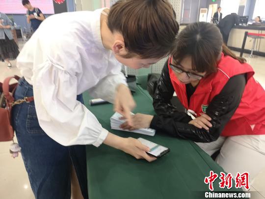 市民向志愿者咨询如何使用电子社保卡?！≌澎匣?摄
