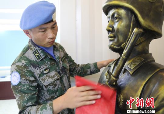 卞龙擦拭申亮亮烈士的雕像?！⊙钤傩?摄