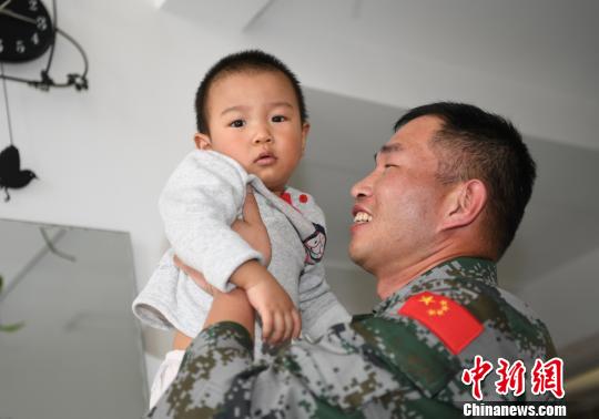 卞龙抱起儿子?！⊙钤傩?摄