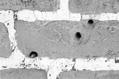 黄楼院长城敌楼上的一块青砖，分布着弹孔