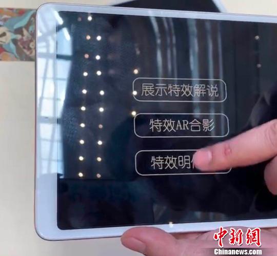 工作人员示范裸眼AR技术?！≈有?摄