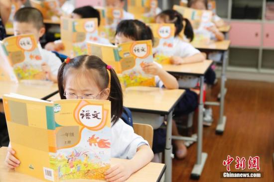 资料图:孩子们正在认真阅读《语文》教材。 殷立勤 摄 点击进入下一页