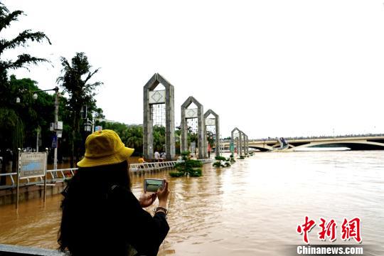 图为一民众在桂林解放桥滨江路拍摄洪水。　唐梦宪 摄