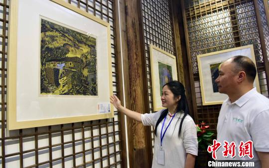 6月12日，松溪版画院院长蔡丽(左)与松溪版画院顾问兰坤发(右)一起欣赏版画作品?！≌爬鼍?摄