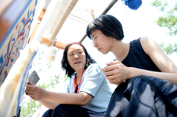 7活动现场，参观者听取牧民讲诉骆驼毛毛毯的纺织技艺