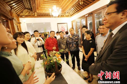 图为当晚在中国驻东盟大使官邸举办的“中国民俗文化之夜”，各国外交官赏花艺。　林永传 摄