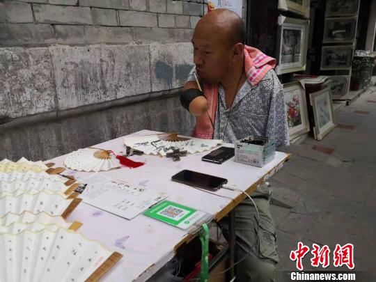 西安残臂男子练习书法20余年写字助其“自立”人生
