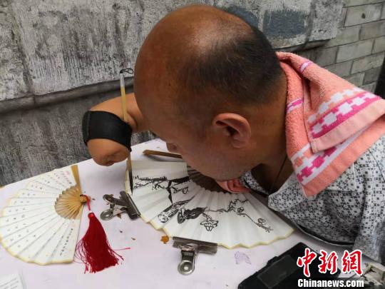 贾维军在扇面上写字?！“⒘漳?摄