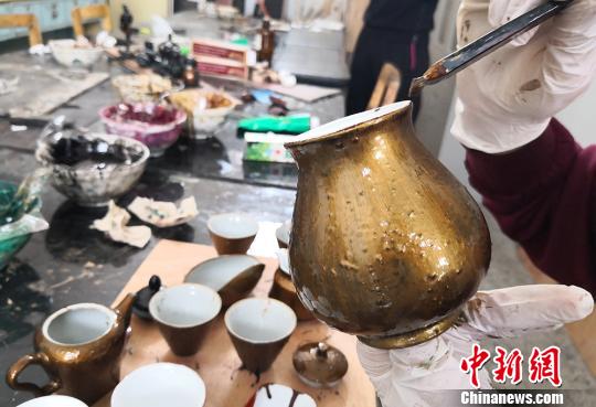 图为学生给茶杯上漆?！×跤裉?摄